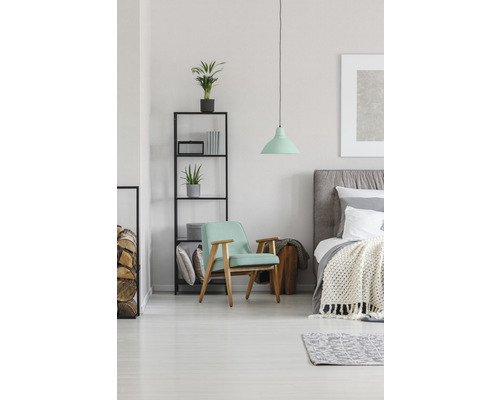 Schlafzimmer mit Bett, Sessel, Regal und Pendelleuchte