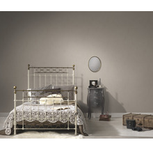 Schlafzimmer mit Bettgestell, Nachttisch, Spiegel und dekorativen Elementen