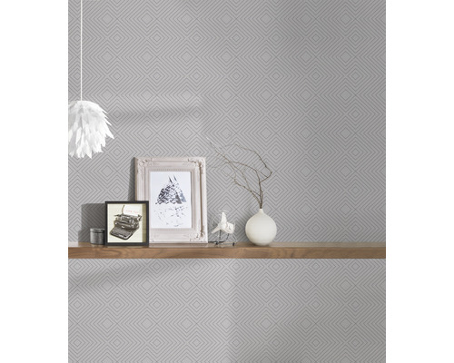 Wohnraum mit geometrischer Tapete, Holzregal und Dekoration