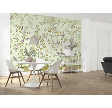 Ein Esszimmer mit einer Wandtapete mit Vogel- und Blumenmuster, einem Esstisch und Stühlen.