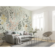 Wohnzimmer mit floraler Fototapete, Sofa und Rattansessel