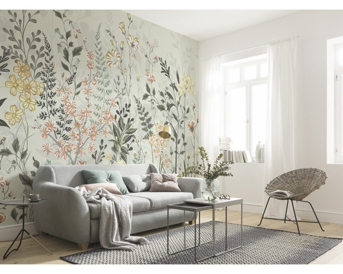 Wohnzimmer mit floraler Fototapete, Sofa und Rattansessel