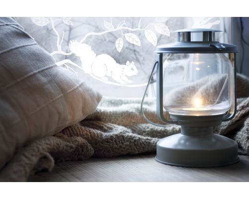 Dekorative Szene mit Kissen, Strickdecke und Laterne mit Kerze