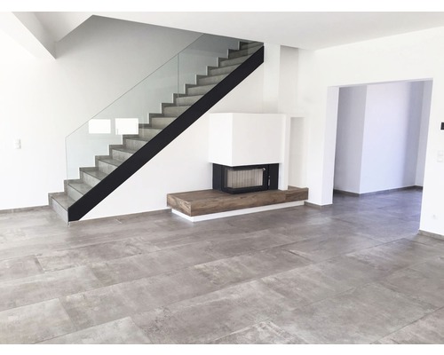 Heller Wohnraum mit Treppe, Kamin und Fliesenboden