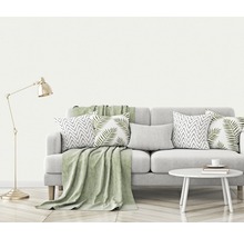Wohnzimmer-Szene mit Sofa, Kissen, Decke, Lampe und Beistelltisch
