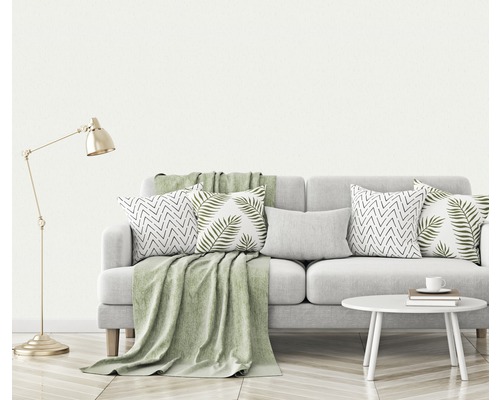 Wohnzimmer-Szene mit Sofa, Kissen, Decke, Lampe und Beistelltisch