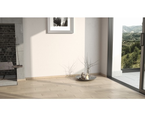 Heller Raum mit Holzboden, Kamin und Blick ins Grüne