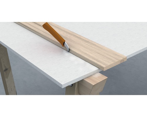 Eine Furnierkante wird mit einem Furnierschneider bearbeitet.