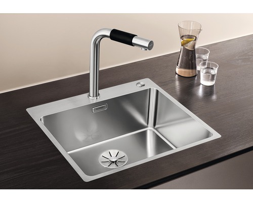 Spüle aus Edelstahl mit Wasserhahn auf einer Arbeitsplatte