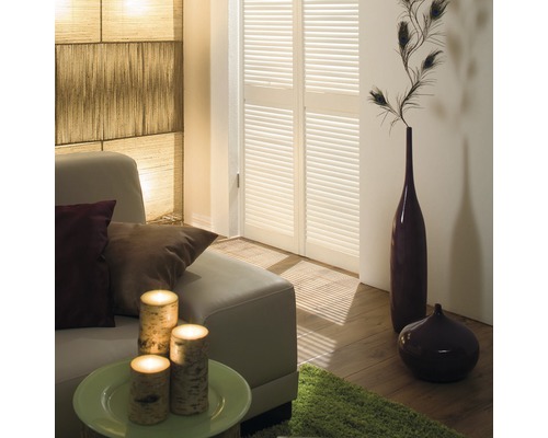 Wohnzimmer mit Sofa, Kerzen, Dekoration und Fensterjalousien für eine gemütliche Atmosphäre