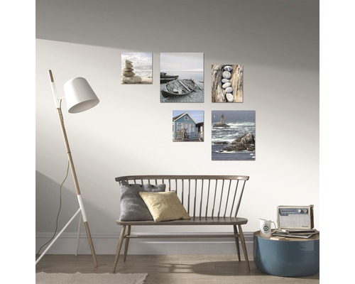 Wanddekoration mit Landschaftsmotiven über einer Holzbank im Wohnzimmer