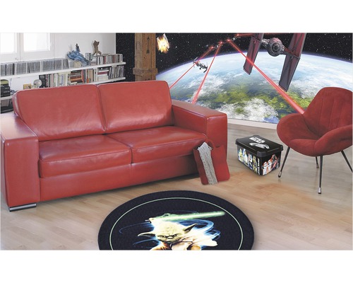 Wohnzimmer mit rotem Sofa, rundem Teppich mit Yoda Motiv und Star Wars Dekoration