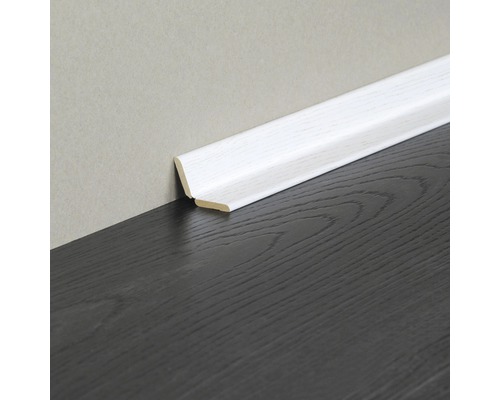 Weiße Fußleiste aus Holz an dunklem Holzboden und heller Wand