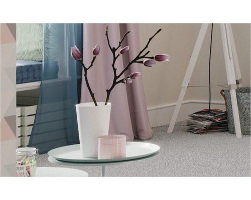 Dekoratives Wohnambiente mit Tisch, Lampe und Textilien