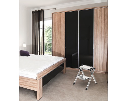 Schlafzimmer mit Bett, Schiebetürenschrank und Trittleiter