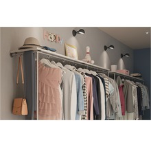 Offene Garderobe mit Kleidung, Hut und Dekoration