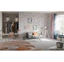Helles Schlafzimmer mit Bett, Sofa, Schreibtisch und geometrischer Tapete