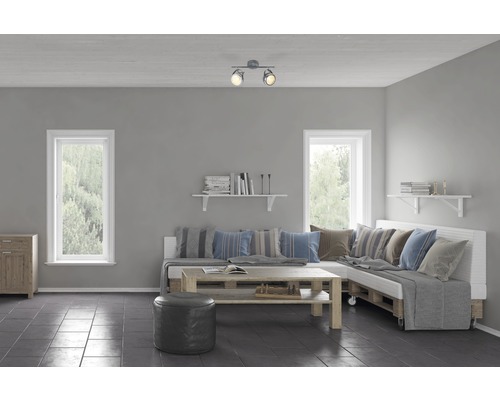 Wohnzimmer mit Palettensofa, Holztisch, Deckenleuchte und Fenstern.