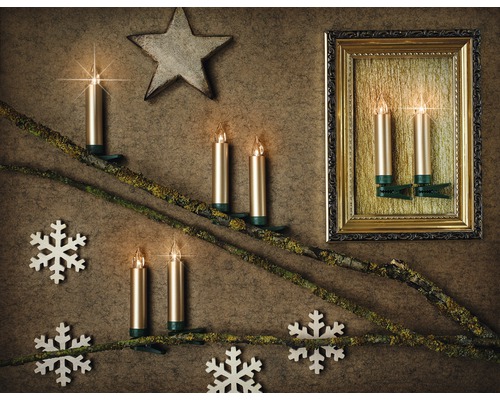 Dekorative Anordnung mit elektronischen Kerzen auf Zweigen, Stern und Schneeflocken vor einem Bilderrahmen
