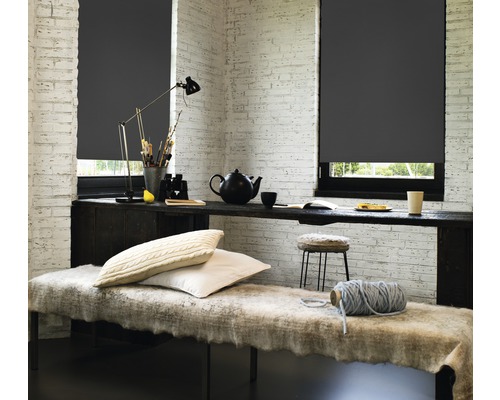 Helles Zimmer mit grauen Rollos vor den Fenstern, Tisch, Bank und Dekorationen