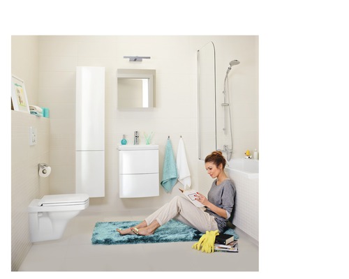 Badezimmer mit Toilette, Waschtisch, Spiegelschrank, Hochschrank und Badewanne.