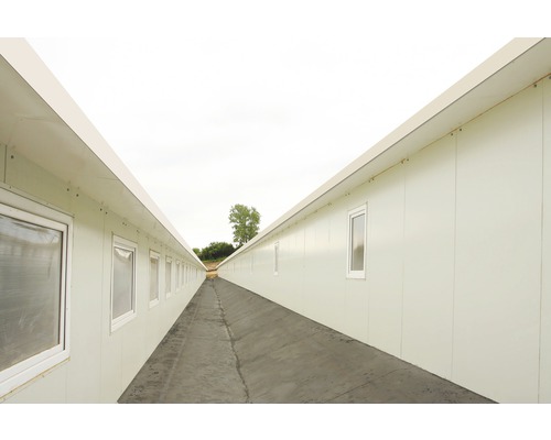 Langer Gang zwischen zwei Reihen von Bürocontainern mit Fenstern