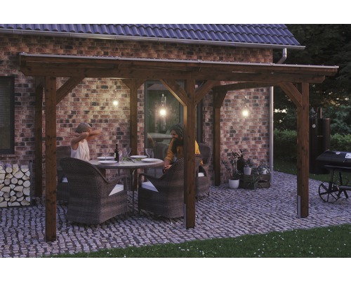 Terrassenüberdachung SKAN HOLZ Siena 434x250 cm nußbaum Holzpergola mit Sitzgruppe auf gepflasterter Terrasse vor einem Backsteinhaus
