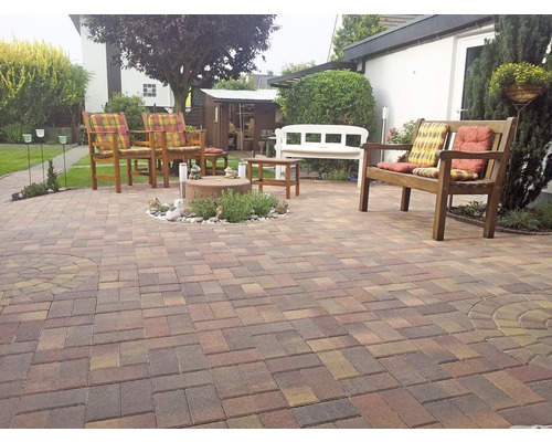 Gartenbereich mit Steinboden, Gartenmöbeln und Bepflanzung