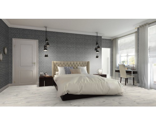 Helles Schlafzimmer mit Bett, Nachttischen, Schreibtisch und Backsteinmauer