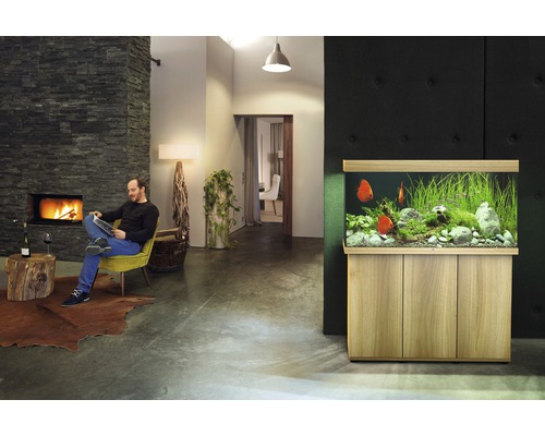 Wohnzimmer mit Aquarium, Kamin und sitzendem Mann