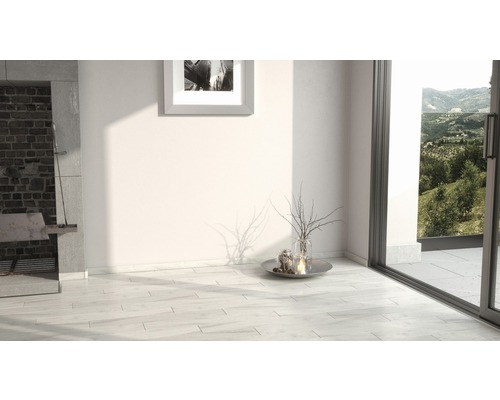 Heller Raum mit Fliesenboden, Kamin und Fensterfront