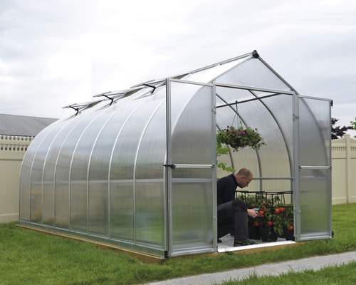 Gewächshaus mit Person bei der Gartenarbeit im Inneren