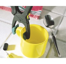 Gelbe Tasse wird mit einer Federklemme fixiert, um einen Klebevorgang zu unterstützen.