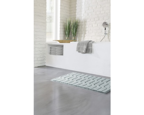 Badezimmer mit Badewanne, Handtüchern, Dekoration und Badteppich