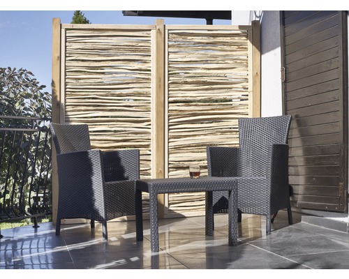 Terrasse mit Sichtschutzzaun, zwei Rattansesseln und einem Rattantisch