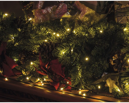 Weihnachtsdekoration mit Tannengirlande, Lichterkette und Tannenzapfen