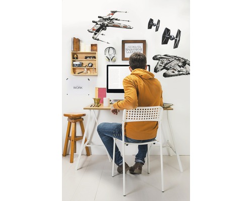 Einrichtung eines Arbeitsplatzes mit Schreibtisch, Stuhl und Wanddekoration mit Star Wars Motiven.