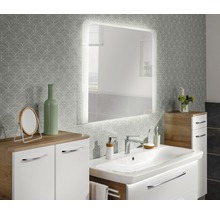 Badezimmer mit Waschtisch, beleuchtetem Spiegel und Unterschrank