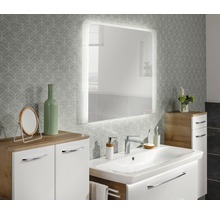 Modernes Badezimmer-Interieur mit beleuchtetem Spiegel, Waschtisch und floraler Tapete