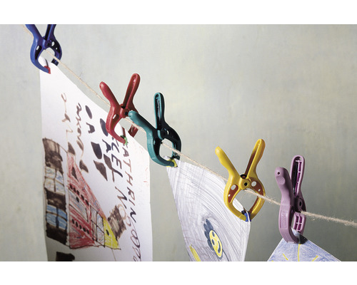 Bunte Wäscheklammern halten Kinderzeichnungen an einer Wäscheleine