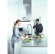 Moderne Küche mit Dunstabzugshaube, Spültischarmatur und zwei Personen beim Kochen