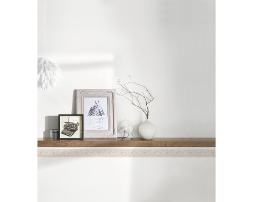 Dekoratives Regal mit Bildern und Accessoires an der Wand