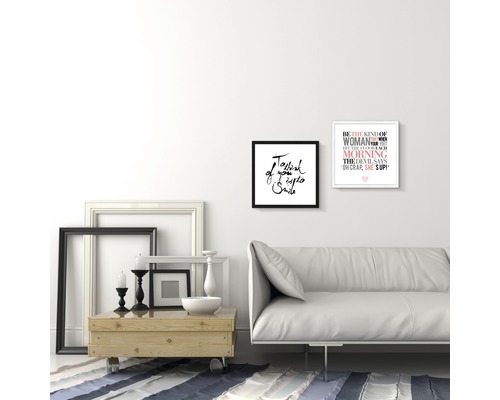 Wohnzimmer mit Sofa, Couchtisch und gerahmten Bildern an der Wand