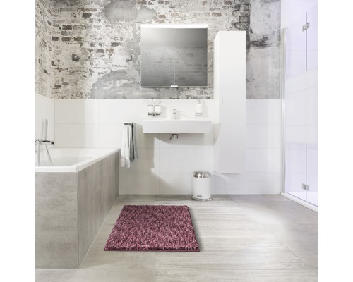 Badezimmer mit Badewanne, Waschbecken, Spiegelschrank, Hochschrank, Treteimer und Teppich