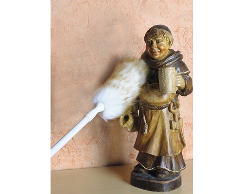 Staubwedel reinigt Mönchsfigur aus Holz