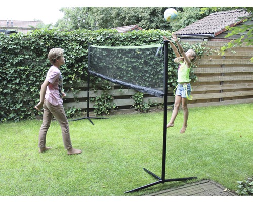 Zwei Kinder spielen mit einem Netz im Garten.