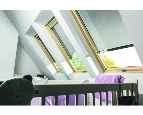 Dachfenster mit Holzrahmen in einem Kinderzimmer mit Babybett.