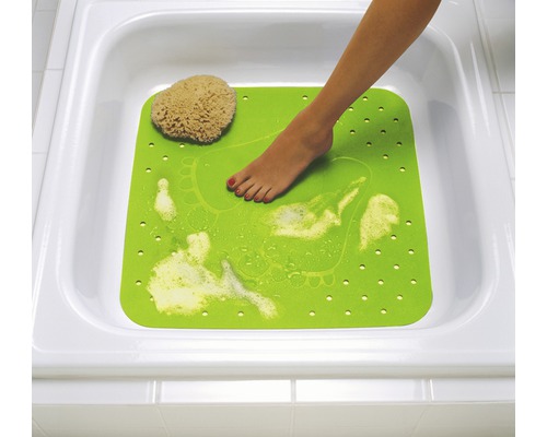 Grüne Badewannenmatte mit Fußabdruck und Badeschwamm in einer weißen Badewanne.