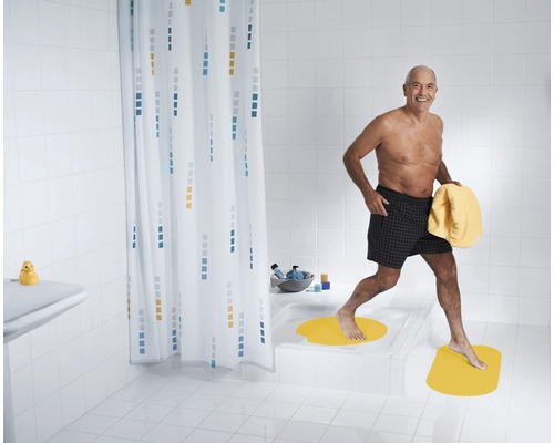 Badezimmer mit Badewanne, Duschvorhang und Badematten für mehr Sicherheit