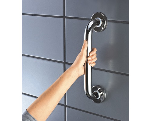 Hand hält einen Haltegriff aus Edelstahl an einer Wand